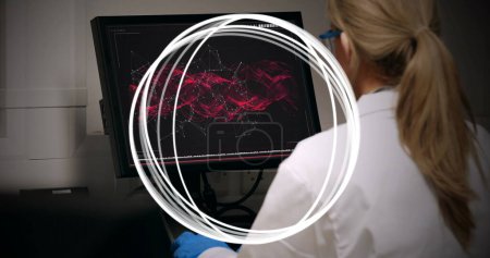 Téléchargez les photos : Image de cercles tournant autour d'une femme scientifique utilisant un ordinateur. concept global de science, de recherche, de traitement de données et d'interface numérique image générée numériquement. - en image libre de droit