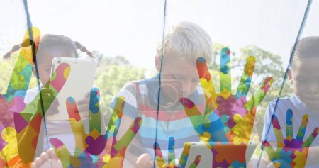 Foto de Imagen de coloridas manos sobre los amigos de los niños usando dispositivos electrónicos. autismo, dificultades de aprendizaje, apoyo y concepto de conciencia imagen generada digitalmente. - Imagen libre de derechos
