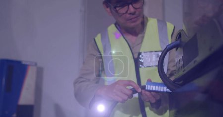 Téléchargez les photos : Image d'une lumière éclatante sur un homme asiatique travaillant dans un entrepôt. journée du travail, travail, travailleurs, tradition et concept de célébration image générée numériquement. - en image libre de droit
