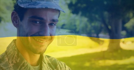 Téléchargez les photos : Image du drapeau de l'ukraine sur heureux soldat masculin biracial. ukraine crise et politique internationale concept image générée numériquement. - en image libre de droit