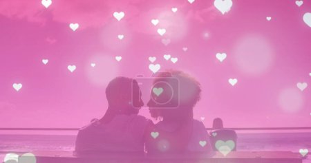 Foto de Múltiples iconos brillantes del corazón cayendo sobre una pareja afroamericana besándose en la playa. Concepto de amor y relación - Imagen libre de derechos