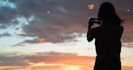 Téléchargez les photos : Image de nous suivre au milieu de la femme prenant des photos avec smartphone au coucher du soleil. connexions mondiales, médias sociaux, technologie et concept d'interface numérique image générée numériquement. - en image libre de droit