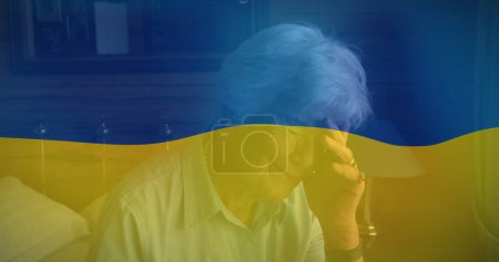 Foto de Imagen de la bandera de Ucrania sobre la mujer mayor caucásica llorando. crisis ucraniana y concepto de política internacional imagen generada digitalmente. - Imagen libre de derechos