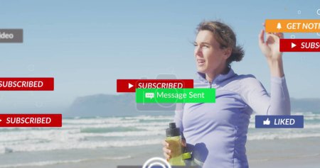 Image of social media notifications, over woman taking break from exercising on beach. social media, positive feelings, wellbeing and communication network concept, digitally generated image.