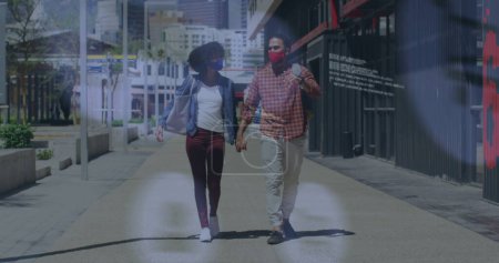 Téléchargez les photos : Image d'icônes des médias sociaux sur un couple afro-américain tenant la main marchant dans la rue. Concept de technologie de réseautage social - en image libre de droit