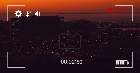 Foto de Imagen de tráfico nocturno en movimiento rápido y paisaje urbano, vista en una pantalla de una cámara digital en modo de grabación con iconos y temporizador - Imagen libre de derechos