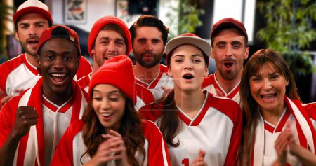 Téléchargez les photos : Vue de face des fans de sport portant des maillots blancs et rouges acclamant leur équipe - en image libre de droit