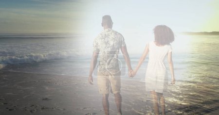 Téléchargez les photos : Image d'un couple afro-américain tenant la main sur la plage au-dessus de la mer. passer du temps libre ensemble concept image générée numériquement. - en image libre de droit
