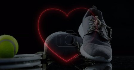 Téléchargez les photos : Image de coeur néon sur des chaussures de ballon et de sport. Sport, fitness, mode de vie actif et fonctions de vie concept de surveillance image générée numériquement. - en image libre de droit