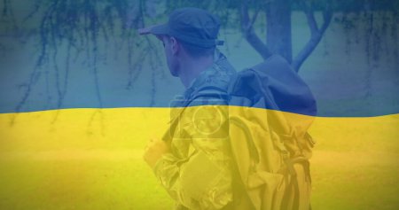 Image of flag of ukraine over caucasian male soldier. ukraine crisis and international politics concept digitally generated image.