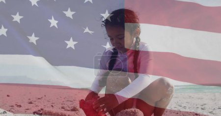Téléchargez les photos : Image du drapeau des États-Unis d'Amérique sur une fille biraciale jouant avec le sable sur la plage. Patriotisme américain, diversité et concept de tradition image générée numériquement. - en image libre de droit