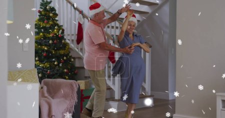 Bild von Schnee, der über ein älteres kaukasisches Paar fällt, das Weihnachtsmänner trägt und tanzt. Weihnachten, Tradition und Festkonzept digital generiertes Image.