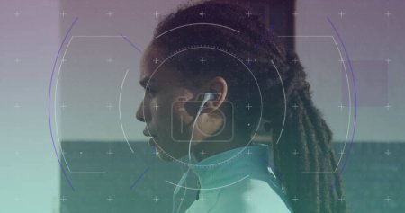 Scope scanning against portrait of african american fit woman wearing earphones. sports, fitness and technology concept