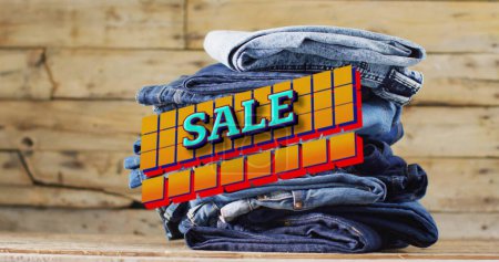 Photo for Image of sale text over denim trousers on wooden background. Sales, retail, shopping, digital interface, communication, computing and data processing concept digitally generated image. - Royalty Free Image