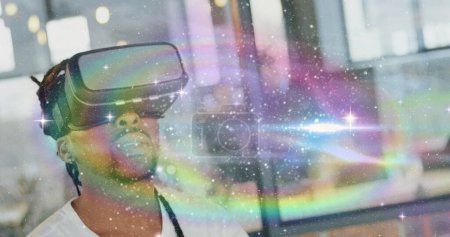 Foto de Imagen de interfaz digital con universo sobre hombre usando auriculares VR y tocando la pantalla virtual en el fondo. Imagen digital global generada digitalmente. - Imagen libre de derechos