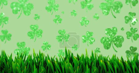 Image of clovers and grass on green background. st patricks day and celebration concept digitally generated image.