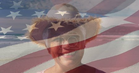 Foto de Imagen de la feliz mujer afroamericana mayor en la playa sobre la bandera americana. patriotismo americano, ocio, vacaciones y vida familiar concepto de imagen generada digitalmente. - Imagen libre de derechos