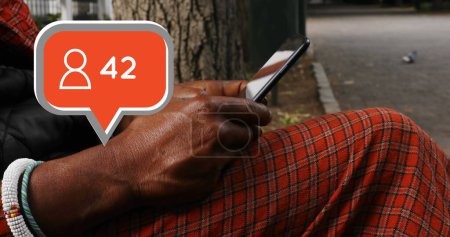Téléchargez les photos : Gros plan d'un vieil homme afro-américain tapant sur un téléphone intelligent. Image numérique d'une bulle de message avec une icône d'adepte qui augmente en nombre - en image libre de droit