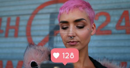 Téléchargez les photos : Gros plan d'une femme punk vérifiant son téléphone avec une icône de coeur nombres croissants ci-dessous - en image libre de droit