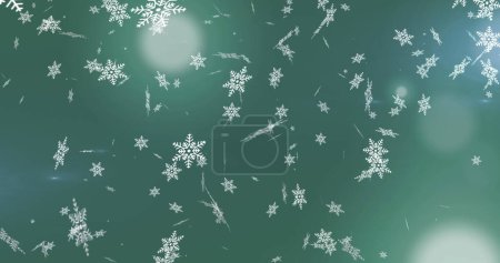 Foto de Imagen digital de copos de nieve cayendo contra manchas de luz sobre fondo verde. fiesta de Navidad y concepto de celebración - Imagen libre de derechos