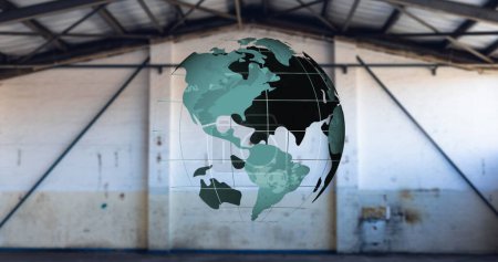 Bild eines sich drehenden grünen Globus über einer leeren Lagerhalle. Globale Verknüpfungen und Technologiekonzept digital generiertes Bild.