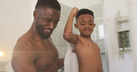 Image of lights over happy african american father and son taking selfie in bathroom. family, togetherness, spending quality time concept digitally generated image.