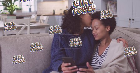 Image of girl power text over two woman using smartphone. female power, feminism and gender equality concept digitally generated image.