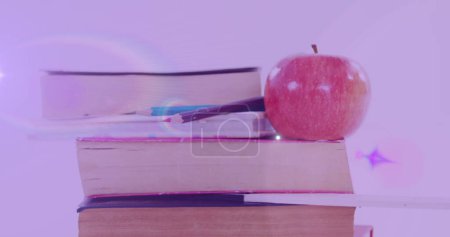 Téléchargez les photos : Image d'une lumière brillante sur la pomme sur une pile de livres. Journée internationale de l'alphabétisation et concept de lecture image générée numériquement. - en image libre de droit