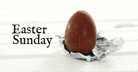 Photo for Image of easter sunday over chocolate egg on white background. easter, spring, tradition and celebration concept digitlaly generated image. - Royalty Free Image