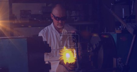 Photo for Image of glowing light over caucasian man working in workshop. labor day, work, workers, tradition and celebration concept digitally generated image. - Royalty Free Image