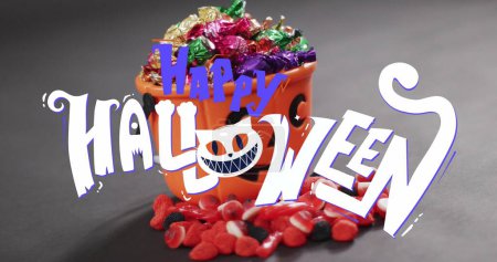 Photo for Image of happy halloween text over orange pumpkin bucket with sweets. halloween tradition and celebration concept digitally generated image. - Royalty Free Image