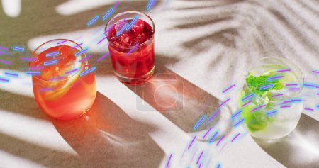 Image of light trails and cocktails on white background. Party, drink, entertainment and celebration concept digitally generated image.