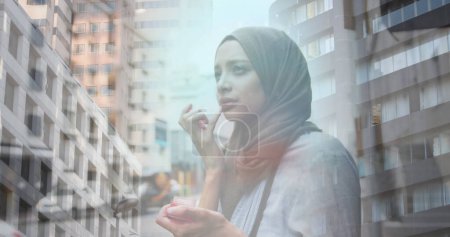 Foto de Imagen de mujer asiática en hijab de pie en la ciudad sobre paisaje urbano. en la ciudad, imagen generada digitalmente. - Imagen libre de derechos