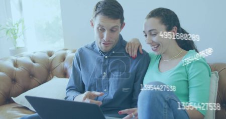 Photo for Image of numbers changing over caucasian couple using laptop. Global business, finance and data processing concept digitally generated image. - Royalty Free Image