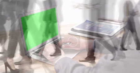 Photo for Image of hands using laptop with green screen over sped up commuters walking in modern building. business and communication technology concept digitally generated image. - Royalty Free Image