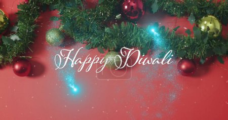 Image of happy diwali text over christmas decorations. Christmas and digital interface concept digitally generated image.
