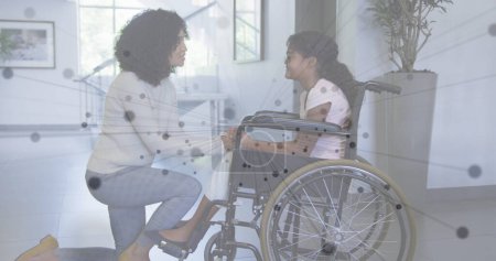 Foto de Imagen de red de conexiones sobre madre e hija afroamericana en silla de ruedas. medicina global, discapacidad, salud y tecnología concepto de imagen generada digitalmente. - Imagen libre de derechos