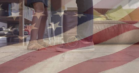 Foto de Imagen de la bandera de EE.UU. ondeando sobre los pies del padre afroamericano bailando con su hija. patriotismo americano, concepto de independencia y celebración imagen generada digitalmente. - Imagen libre de derechos