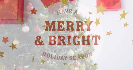 Photo for This image shows a christmas tree decorated with baubles on a white background. The image shows merry and bright text over stars falling and presents at christmas. - Royalty Free Image