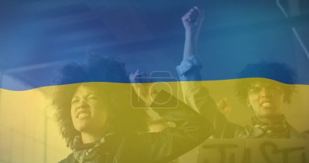 Image of flag of ukraine over african american male and female protesters. ukraine crisis and international politics concept digitally generated image.