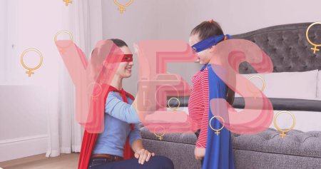 Image of yes text over superhero mother and daughter. female power, feminism and gender equality concept digitally generated image.