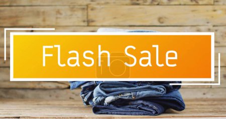 Photo for Image of flash sale text over denim trousers on wooden background. Sales, retail, shopping, digital interface, communication, computing and data processing concept digitally generated image. - Royalty Free Image