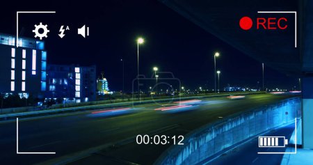 Téléchargez les photos : Image du trafic nocturne en mouvement rapide, vue sur un écran d'un appareil photo numérique en mode enregistrement avec icônes et minuterie - en image libre de droit