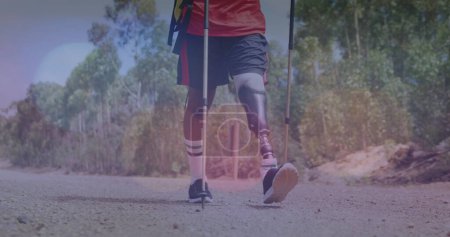 Bild von hellen Flecken über einem behinderten Mann, der in den Bergen wandert. Spaziergang- und Festkonzept digital generiertes Image.
