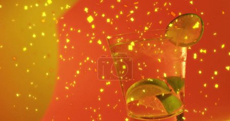 Image of confetti falling and cocktail on red background. Party, drink, entertainment and celebration concept digitally generated image.