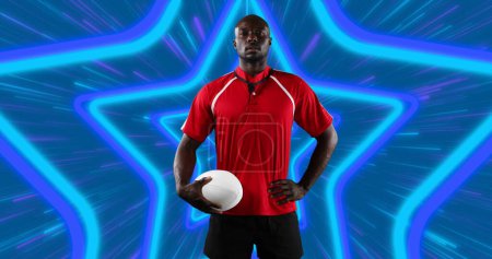 Foto de Jugador de rugby masculino afroamericano sosteniendo la pelota de rugby contra las formas de estrellas de neón en un patrón sin costuras. concepto de deportes y tecnología - Imagen libre de derechos