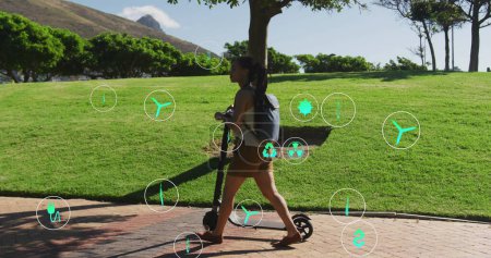 Bild von Öko-Ikonen über eine Frau, die mit Roller im Park spaziert. Gesundheits- und Fitnesskonzept digital generiertes Image.