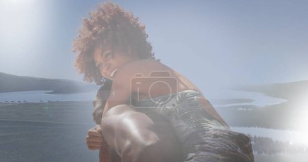 Téléchargez les photos : Image d'une femme afro-américaine se relaxant à la plage ensoleillée sur le paysage. vacances heureuses et temps libre, image générée numériquement. - en image libre de droit