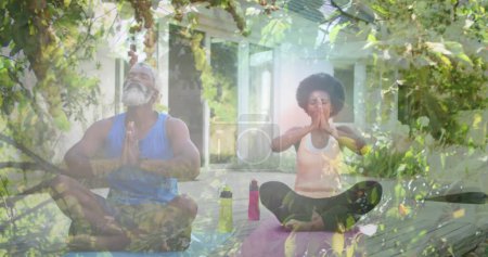 Téléchargez les photos : Image de feuilles sur l'homme et la femme afro-américaine senior pratiquant le yoga et la méditation. Journée mondiale de méditation et concept de célébration image générée numériquement. - en image libre de droit