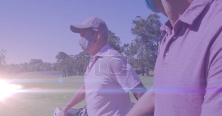 Téléchargez les photos : Image de sentiers lumineux sur les joueurs de golf masculins caucasiens sur le terrain de golf. concept mondial de sport, golf et mode de vie sain image générée numériquement. - en image libre de droit